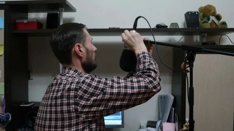 A man sets up a microphone on the computer at home Stock Footage 102554173
