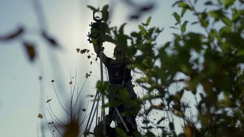 Man sets a retro camera among green bushes Stock Footage 72102008