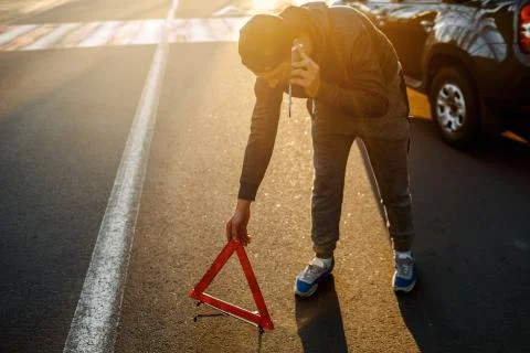 A man sets up a road triangle and calls the police, or a car service. Traffic Stock Photos