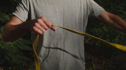 Man sets slackline between trees above the river. 스톡 동영상 140762356
