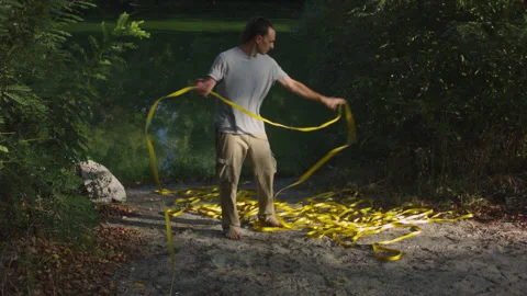 Man sets slackline between trees above the river. 스톡 동영상 140762873