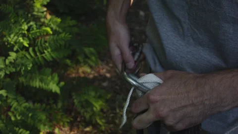 Man sets slackline between trees above the river. 스톡 동영상 140765370