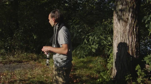 Man sets slackline between trees above the river. 스톡 동영상 140765470