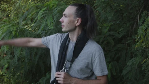 Man sets slackline between trees above the river. 스톡 동영상 140765508