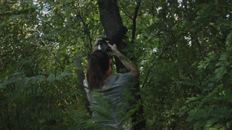 Man sets slackline between trees above the river. 스톡 동영상 140766513