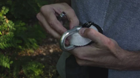 Man sets slackline between trees above the river. 스톡 동영상 140766534