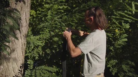 Man sets slackline between trees above the river. 스톡 동영상 140792970