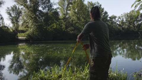 Man sets slackline between trees above the river. Stock-Footage 140797288