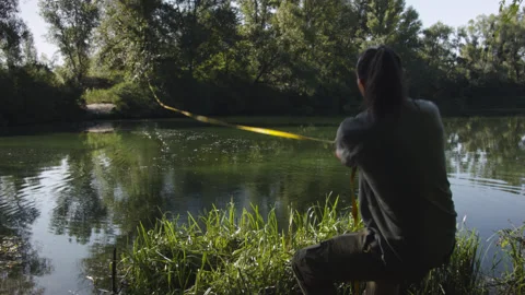 Man sets slackline between trees above the river. 스톡 동영상 140798013