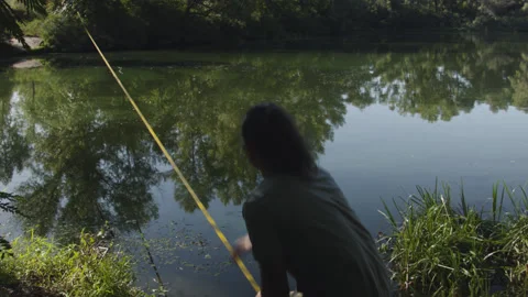 Man sets slackline between trees above the river. 스톡 동영상 140802227