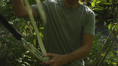 Man sets slackline between trees above the river. 스톡 동영상 140807341