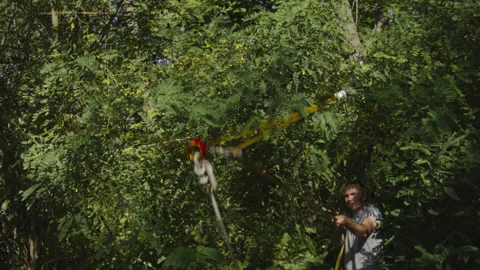 Man sets slackline between trees above the river. 스톡 동영상 140811800