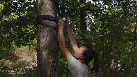 Man sets slackline between trees above the river. 스톡 동영상 140813714