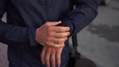 Man sets smart watch timer, runs out of focus. Athlete starts a smart watch Stock Footage 160071021