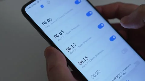 Man setting alarm clock on smartphone, close-up, man planning early wake-up Stock Footage 289118236