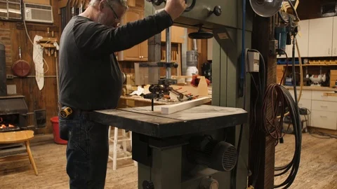 Man setting up band saw to cut piece of wood Stock Footage 102045280