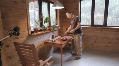 Man Setting Dining Table Inside Cozy Wooden Cabin Before Home Meal Stock Footage 346746496