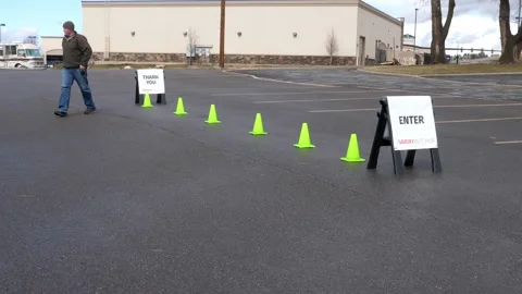 Man setting up enter and thank you signs with cones Video stock 142764364