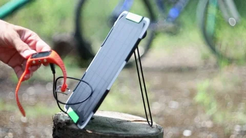Man setting portable solar panel to charge watch from sunlight. Stock Footage 157483313