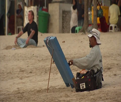 Man setting up sunglass stall on sandy beach Stock Footage 86747326