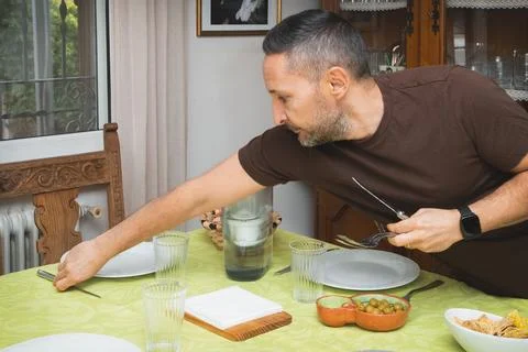 A man is setting a table for lunch Stock-Fotos