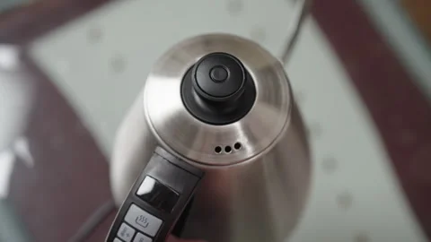 Man setting temperature and timer on electric kettle and closing lid, preparing Stock Footage 306700703