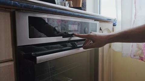 Man setting up the timer on the oven Stock Footage 163990822