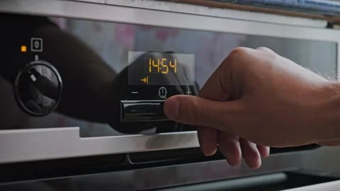 Man setting up the timer on the oven Stock Footage 163991266