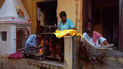 Man sew clothes on sewing machine in his workshop at narrow streets of Varanasi. Stock Footage