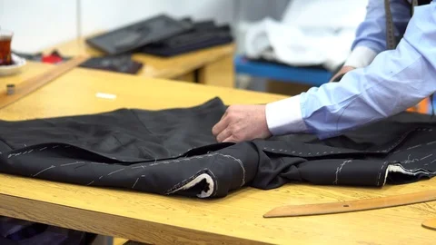 Man sew a sleeve to a jacket, closeup view. tailoring menswear to order. Vidéo 85584972