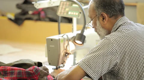 Man sewing with a sewing machine Stock Footage 31458523