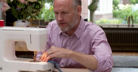 Man sewing at sewing machine, medium shot, 4K Stock Footage 91027584