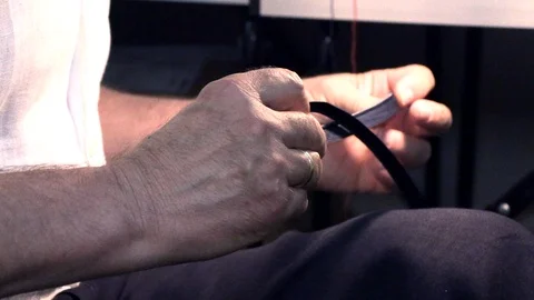 A man sews clothes in a hand Видео 94175770