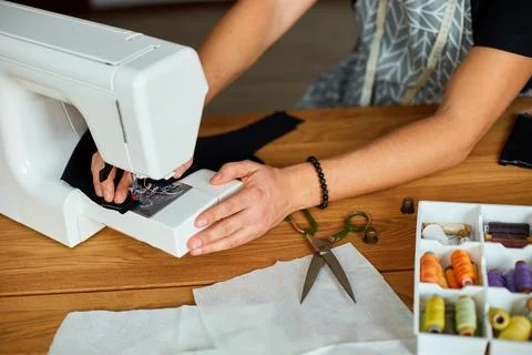 Man sews clothes on sewing machine,  male tailor working with sewing in ateli Stock Photos