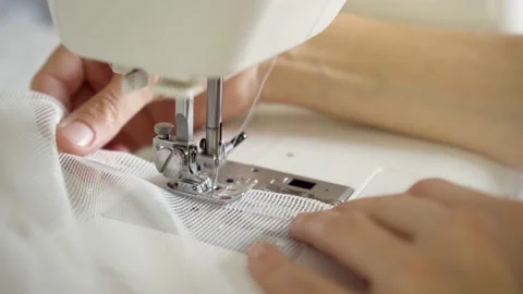 Man sews at a sewing machine. Designer sitting and sewing. Dressmaker working on Stock Footage 162848877