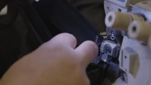 Man sews at a sewing machine. Designer sitting and sewing. Dressmaker working on Stock Footage 254485076