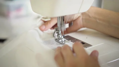 Man sews at a sewing machine. Dressmaker working. Concept of clothing production Stock Footage 168800569