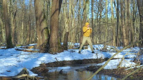 Man shadow boxing outdoors in snowy spring forest near flowing stream Stock Footage 337055155