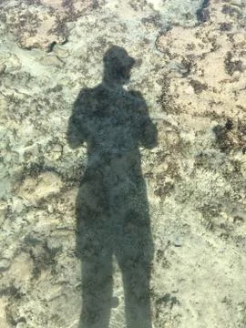 Man Shadow under water on sand background Stock Photos