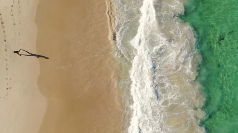 Man With Shadow Walking on Beach Stock Footage 123766025