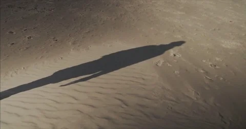 Man / shadow walking in sand in slomotion Stock Footage 83867642