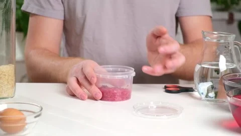 A man shakes container of rice evenly color rice. An unusual way coloring and Stock Footage 236920891