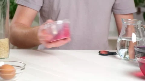 A man shakes container of rice evenly color rice. An unusual way coloring and Stock Footage 241424070