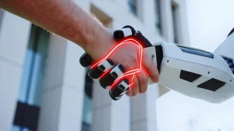 A man shakes hands with a humanoid robot, symbolizing humantech collaboration Stock Footage 316830627