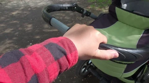 Man shakes stroller with sleeping newborn baby on street summer Stock Footage 154812166