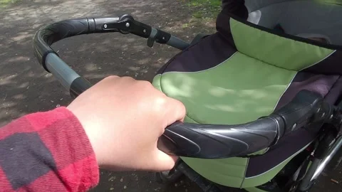 Man shakes stroller with sleeping newborn baby on street summer Stock Footage 154812247
