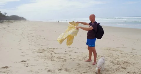 Man shaking and folding his beach towel Stock Footage 87989164