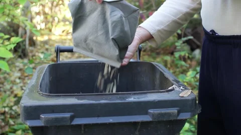 Man shaking a bag vacuum cleaner in the trash after his wife made ​​up 1 Vídeo Stock 59757130