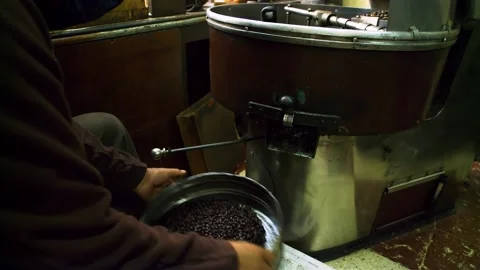 Man shaking roasted coffee beans in sieve to clean them from debris and chaff. Stock Footage 277533624