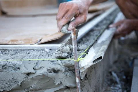Man shape the edge of the floor with plasterer concrete cement Stock Photos